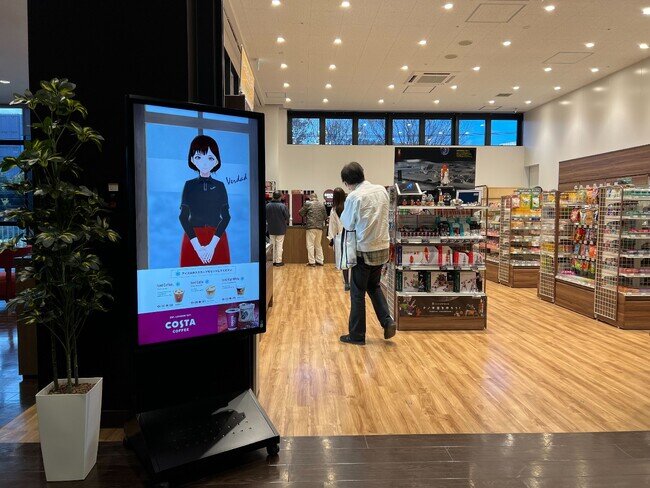 画像：無人の社内売店でバーチャル店員がお出迎え。人感センサーでオススメ商品をご紹介！